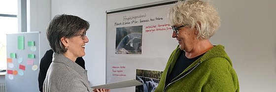 Bernadette Schwarz-Boenneke (links) überreicht der Teilnehmerin Ursula Pöttgen (rechts) die Ernennungsurkunde.